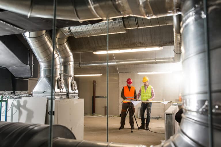 A couple of men standing next to each other in a construction site