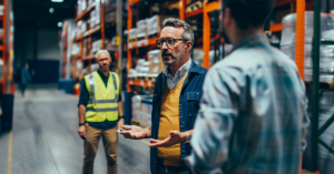 warehouse leader speaking to warehouse workers in a warehouse